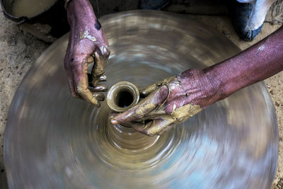 Cropped hands of potter making pot