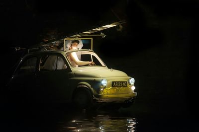 Car in illuminated water at night