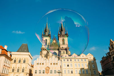 Low angle view of historic church seen through bubble against blue sky