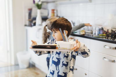 Boy carrying food tray in preschool