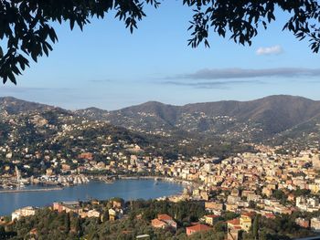 Aerial view of townscape by bay against sky