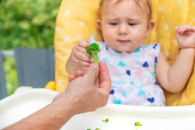 Cute baby eating broccoli