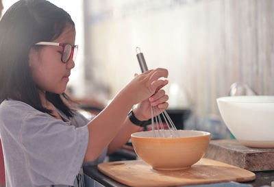 Woman holding ice cream in bowl on table