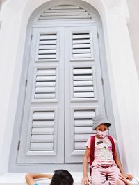 Portrait of woman standing against building