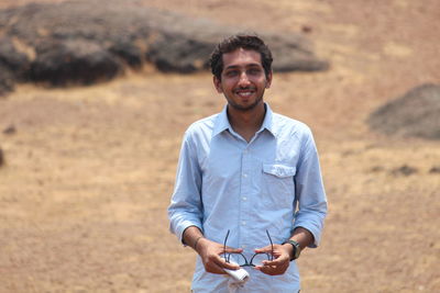 Portrait of smiling young man standing outdoors