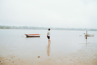 Rear view of man on beach against sky