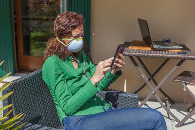 Man using mobile phone while sitting on chair