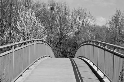 Footbridge over footpath against sky