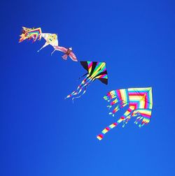 Low angle view of kite against clear blue sky