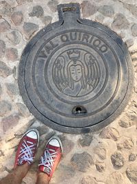 Low section of person standing on manhole