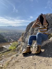Rear view of woman looking at mountain against sky