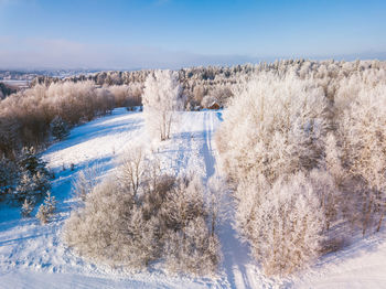 Scenic view of snow covered field against sky
