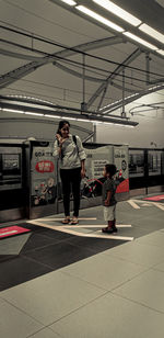 Full length of people standing on tiled floor