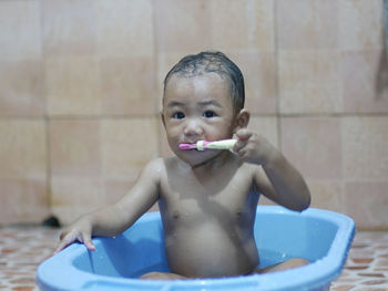 Portrait of shirtless baby boy in bathroom at home