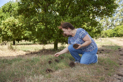 Side view of woman sitting on grassy field