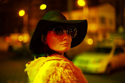 Close-up portrait of woman wearing sunglasses and hat