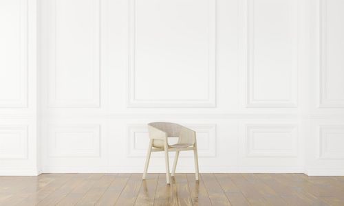 Empty chair against white wall