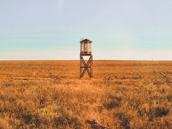 Lookout tower on field against sky