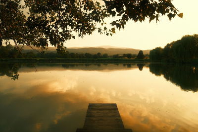 Scenic view of lake against sky at sunset