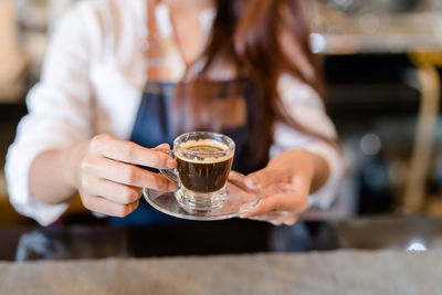 Midsection of woman holding coffee cup