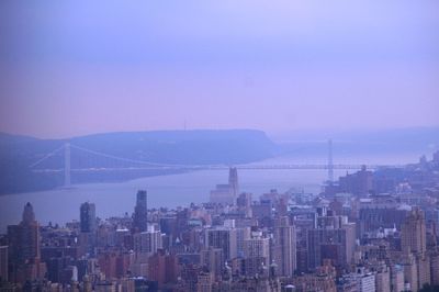 Bridge and buildings in city against sky