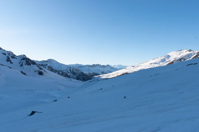 Scenic view of snowcapped mountains against clear blue sky