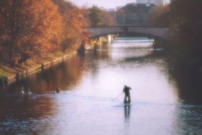 Silhouette of man on bridge over river