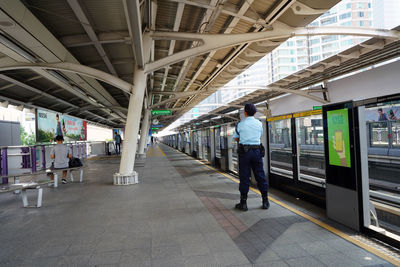 Rear view of people walking on railroad station platform