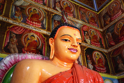Low angle view of buddha statue against building