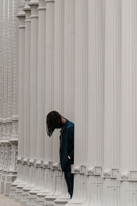 Man standing by columns of building