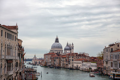 View of buildings in city against cloudy sky