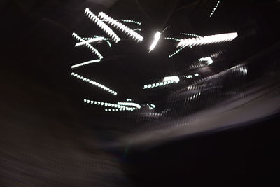Low angle view of illuminated lights at night
