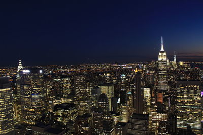 Illuminated cityscape against sky at night