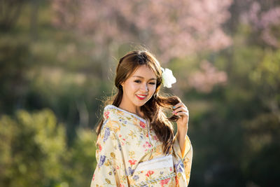 Portrait of smiling young woman standing outdoors