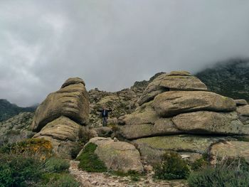 Rear view of rocks on mountain against sky