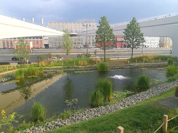 River by buildings in city against sky