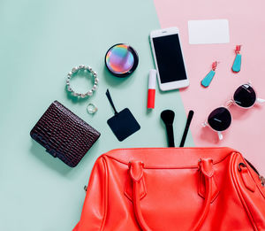 Directly above shot of smart phone with beauty products on table