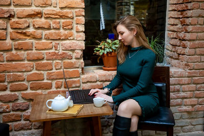 Beautiful woman using laptop while sitting at cafe