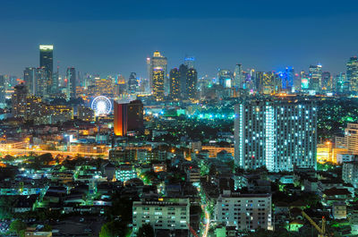 Illuminated cityscape against sky at night