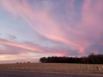 Scenic view of field against sky at sunset