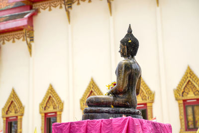 Statue outside temple against building