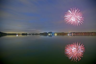 Reflection of firework display in river at night