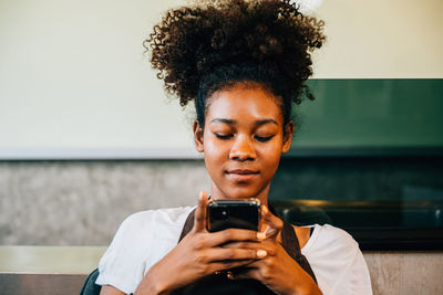 Young woman using mobile phone at home