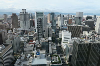 Aerial view of buildings in city against sky