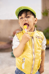 Portrait of cute boy eating lollipop outdoors