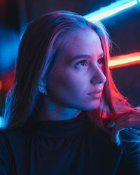 Young woman looking away in illuminated room