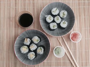 Directly above shot of sushi in containers on place mat