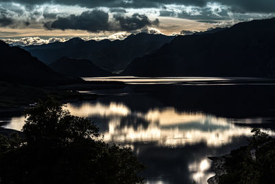 Scenic view of lake and mountains against sky at sunset