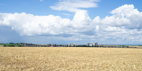 Panoramic view of agricultural field against sky