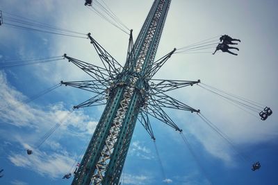 Low angle view of chain swing ride against cloudy sky